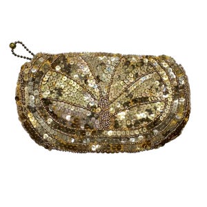 May include: A gold sequined clutch with a beaded handle. The clutch is covered in small, round, gold sequins arranged in a fan-like pattern. The sequins catch the light, creating a shimmering effect. The clutch has a rounded shape and a small beaded handle.