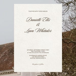 May include: A white rectangular wedding invitation card with a textured paper finish. The text reads: Together with their families, Danielle Ellis & Liam Whitaker, Saturday, September twenty-first, two thousand thirty, at five o'clock in the afternoon, Silverwood Garden House, 1287 Beacon Street, Boston, Massachusetts, Reception to follow.