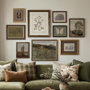 May include: A collection of framed art pieces, including botanical prints and landscape paintings, arranged on a wall. The frames are in shades of brown and gold. The artwork includes botanical illustrations, sketches, and paintings. The wall is above a green sofa with cushions.