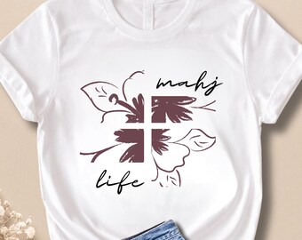 May include: White t-shirt with a floral design in burgundy and the words "mahj life" in black script. The shirt is paired with denim shorts. The overall aesthetic is casual and relaxed.