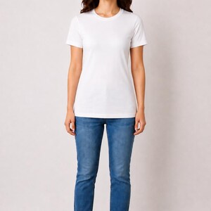 May include: A person wearing a white crew neck t-shirt and blue jeans. The model's height is 5'6" and weighs 130lbs. The shirt size is M.