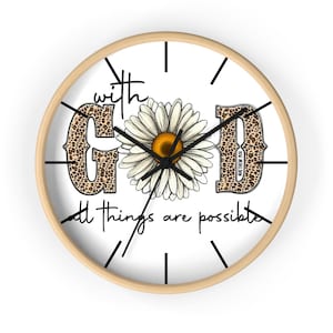 May include: Round wall clock with a light wood frame. The clock face is white with black hands and hour markers. The words "with GOD all things are possible" are printed on the face, along with a daisy and leopard print letters.