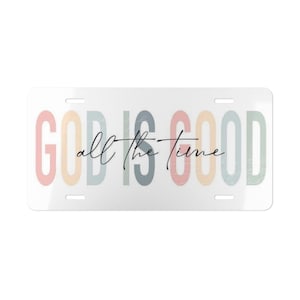 Puede incluir: Placa de matrícula rectangular con la frase "GOD IS GOOD all the time" en colores pastel. Las palabras "GOD IS GOOD" están en letras grandes, y "all the time" en cursiva.