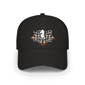 Puede incluir: Gorra de béisbol negra con un caballo de ajedrez y las palabras "YOUR MOVE" en blanco. El diseño incluye un patrón de tablero de ajedrez. Un accesorio elegante para los aficionados al ajedrez.