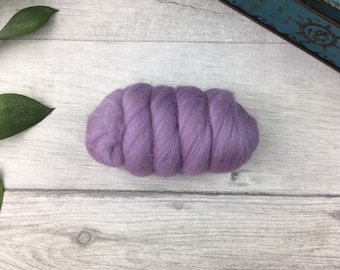 Puede incluir: Un paquete de vellón de lana de color lavanda, un tipo de fibra que se utiliza para el fieltro y el hilado.
