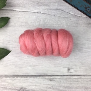 May include: A close-up of a pink wool roving, a type of fibre used for felting and spinning.
