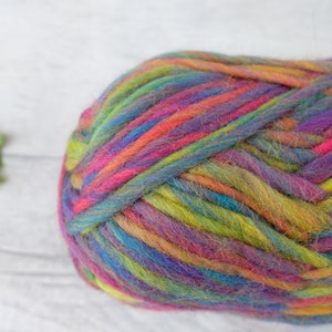 May include: A ball of colorful yarn with shades of pink, purple, blue, green, and yellow. The yarn is soft and fluffy, and it is perfect for knitting or crocheting.