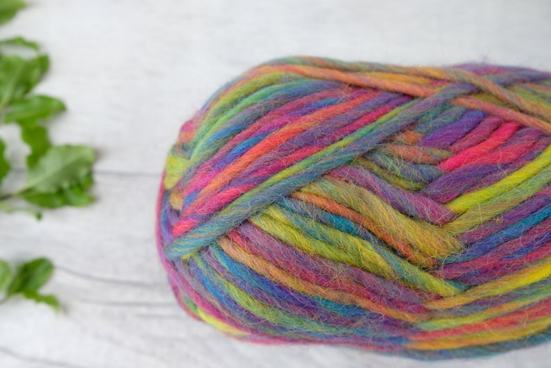 May include: A ball of colorful yarn with shades of pink, purple, blue, green, and yellow. The yarn is soft and fluffy, and it is perfect for knitting or crocheting.
