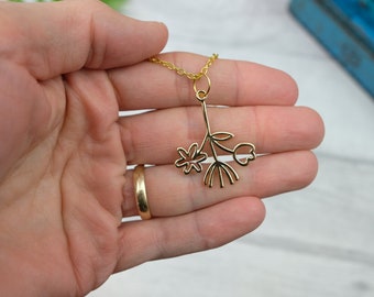 Minimalist flower charm necklace in gold tone