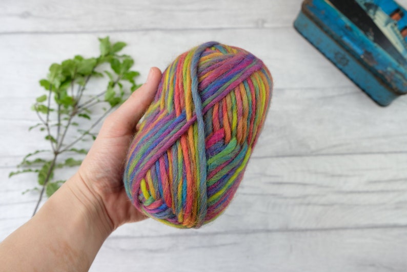 May include: A skein of colorful yarn with stripes of pink, purple, blue, green, yellow, and orange.
