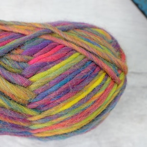 May include: A ball of colorful yarn with shades of pink, purple, blue, green, and yellow.