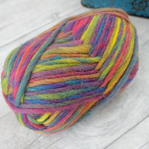 May include: A ball of colorful yarn with stripes of pink, purple, blue, green, yellow, and orange.