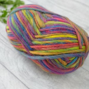 May include: A ball of colorful yarn with stripes of pink, blue, yellow, green, and purple.