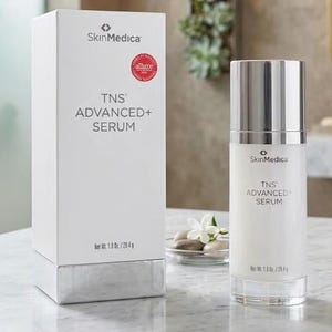 May include: A white SkinMedica TNS ADVANCED+ SERUM box and a matching cylindrical pump bottle. The packaging features black text, a red circular award seal, and states a net weight of 1.0 oz. / 28.4 g. The bottle has a metallic silver cap.