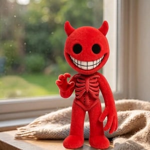 May include: A bright red plush figure with a textured surface, featuring two small horns on its head, large black circular eyes, and a wide, toothy grin. The torso displays a raised, skeletal rib cage design, and the figure has long arms.
