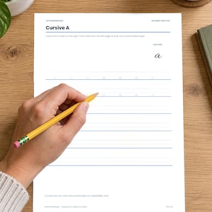 May include: A white practice worksheet for cursive handwriting titled Cursive A, featuring blue horizontal lines and a model letter a. The page includes instructions to look at the model and write from the left edge at a comfortable angle.