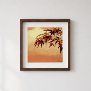 Könnte beinhalten: Ein quadratisches gerahmtes Wandbild mit einer Illustration von Ahornblättern im Aquarellstil in den Farben Dunkelrot, Orange und Gelb. Die Blätter sind in der oberen rechten Ecke vor einem weichen, texturierten Hintergrund angeordnet.