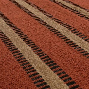 May include: A woven rug featuring a repeating pattern of wide terracotta orange stripes alternating with narrower beige stripes, each bordered by thin, dark black lines. The texture appears dense and fibrous with a consistent, uniform pile.