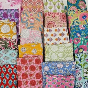 Puede incluir: Una colección de cuadrados de tela doblados que presentan una variedad de patrones florales y botánicos estampados en bloque en colores vibrantes que incluyen rosa, amarillo, azul, verde, rojo y morado, dispuestos en una cuadrícula de muestras.