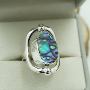 Könnte beinhalten: Ein Set aus drei Keramikbechern mit gesprenkelter, matter Oberfläche. Die Becher sind in Creme-, Hellgrau- und Dunkelgrautönen gehalten. Jeder Becher hat ein schlichtes, modernes Design und einen abgerundeten Henkel.