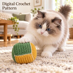 May include: A digital crochet pattern featuring a fluffy cat with blue eyes playing with a small, round, stuffed toy. The toy is constructed from alternating green and yellow crocheted panels joined by white stitching. The text reads Digital Crochet Pattern.