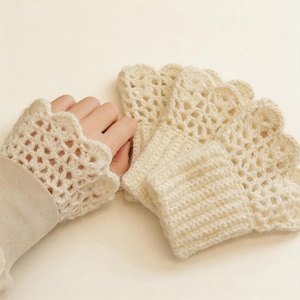 Puede incluir: Guantes sin dedos de crochet color crema con borde festoneado. También se ven varias piezas de crochet a juego. El diseño de tejido abierto y el color neutro sugieren un accesorio delicado y hecho a mano.