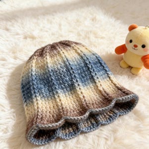 Cappello a secchiello soffice con bordo smerlato: schema all'uncinetto per un look invernale accogliente.