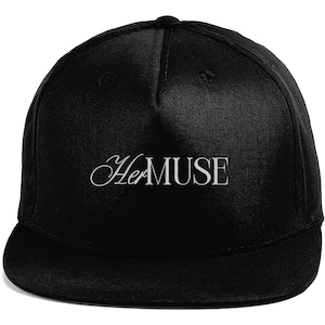 Könnte beinhalten: Schwarze Baseballkappe mit flachem Schirm und dem weißen Schriftzug "Her MUSE" in eleganter Schrift. Die Kappe hat eine strukturierte Krone und einen flachen Schirm, für einen lässigen Stil.