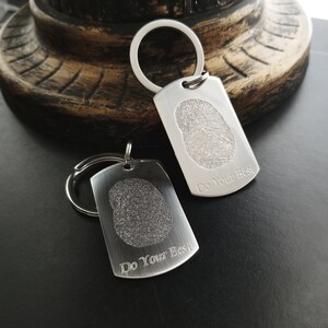 May include: Two silver keychains with a fingerprint design and the text "Do Your Best" engraved on each.