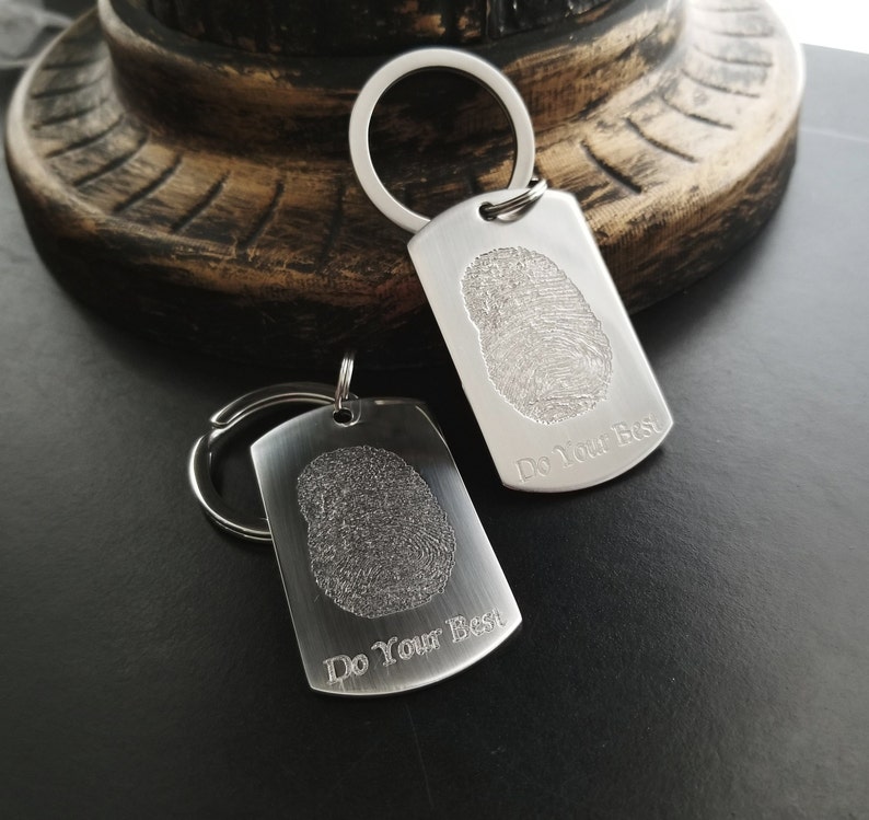 May include: Two silver keychains with a fingerprint design and the text "Do Your Best" engraved on each.