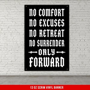 May include: Black banner with white gothic font text: "NO COMFORT, NO EXCUSES, NO RETREAT, NO SURRENDER, ONLY FORWARD." The banner is hanging against a white brick wall. The bottom of the banner reads "13 OZ SCRIM VINYL BANNER."
