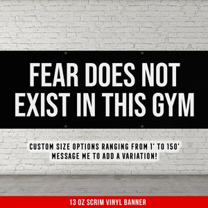 May include: Black banner with white text that reads "FEAR DOES NOT EXIST IN THIS GYM".  The banner is made of 13 oz scrim vinyl and is available in custom sizes from 1 foot to 150 feet.