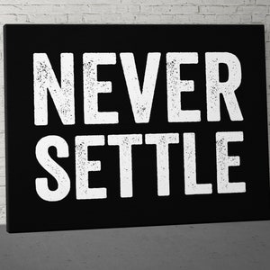 May include: Black canvas wall art with white text that reads "NEVER SETTLE".