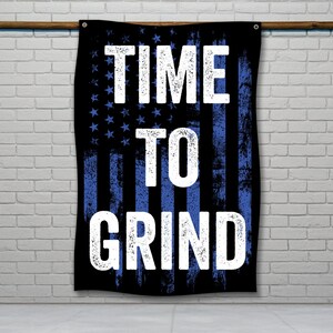 Puede incluir: Una bandera americana negra y azul con las palabras "TIME TO GRIND" en texto blanco.