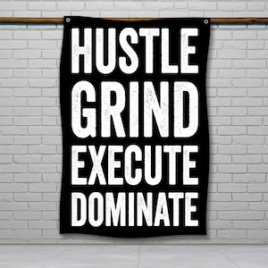 Op de afbeelding: Zwarte banner met witte tekst die "Hustle Grind Execute Dominate" luidt.