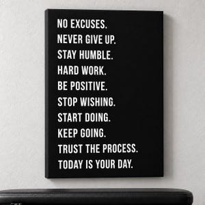 May include: A rectangular black canvas wall art piece featuring white sans-serif text that reads: NO EXCUSES. NEVER GIVE UP. STAY HUMBLE. HARD WORK. BE POSITIVE. STOP WISHING. START DOING. KEEP GOING. TRUST THE PROCESS. TODAY IS YOUR DAY.