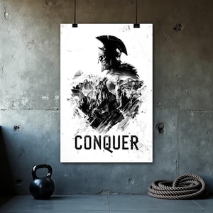 May include: Black and white poster featuring a Spartan warrior with a helmet, set against a mountain range. The word "CONQUER" is printed in bold, black letters at the bottom. The poster is hanging on a gray concrete wall.