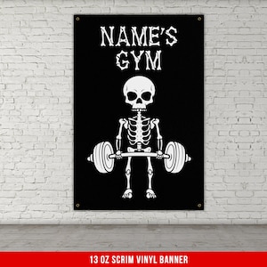 May include: Black and white banner with a skeleton lifting a barbell. The banner says "NAME'S GYM" at the top. 13 oz scrim vinyl banner.