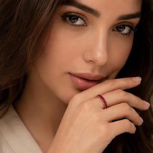Anillo de aniversario de plata de ley con rubí sintético talla esmeralda y alianza de aniversario.