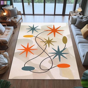 May include: A rectangular area rug with a mid-century modern design. The rug features a cream-colored background with orange, teal, and olive-green starburst shapes connected by a black line. The rug is placed on a hardwood floor.
