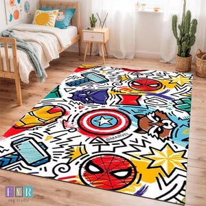以下が含まれることがあります： スパイダーマン、キャプテン・アメリカ、アイアンマンなどのマーベルのキャラクターが描かれた、コミック風のデザインの長方形ラグ。白い背景にカラフルなイラストとマーベルのロゴが描かれています。