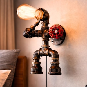 May include: Industrial-style wall sconce made from metal pipes, featuring a vintage Edison bulb. The fixture has a red valve detail and a dark, aged finish, adding a rustic touch to any space.