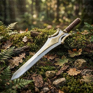 May include: A double-edged sword with a silver blade and a gold-toned crossguard featuring curved accents. The handle is wrapped in brown leather, and the pommel is rounded. The sword rests on a mossy forest floor with scattered brown leaves.