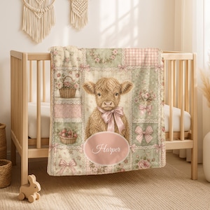 May include: A soft baby blanket featuring a central illustration of a fluffy Highland cow wearing a pink bow. The blanket has a patchwork design with floral patterns, baskets of flowers, and pink bows. The name Harper is printed in a pink oval.