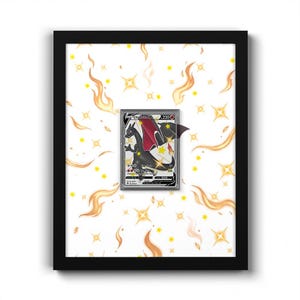 Può includere: Una cornice nera contenente una carta collezionabile Charizard V centrata su uno sfondo bianco con un motivo di stelle gialle a quattro punte e illustrazioni di fiamme arancioni. La carta mostra un drago nero con ali rosse.