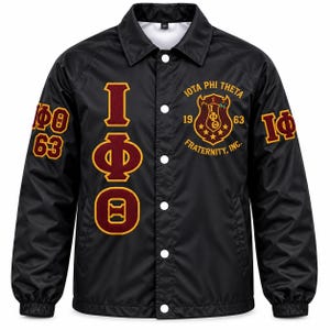 May include: A black button-up jacket featuring the Greek letters Iota Phi Theta in maroon and gold on the right side. The left chest displays a crest with the text Iota Phi Theta Fraternity, Inc. 1963. The sleeves feature the letters Iota Phi 63.