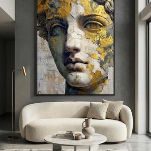 Może przedstawiać: Duży, oprawiony wydruk na płótnie przedstawiający klasyczny popiersie z akcentami ze złotych liści. Grafika ma postarzany, zużyty wygląd z neutralną paletą kolorów, odpowiednią do wystroju wnętrz.