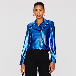 May include: A metallic blue motorcycle jacket with a silver zipper and pockets. The jacket has a classic biker style with a notched collar and long sleeves. The jacket is worn with black pants.