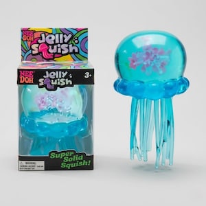 May include: A translucent turquoise jellyfish-shaped squishy toy with purple internal details, standing next to its retail box labeled Nee Doh Jelly Squish. The packaging features colorful swirling patterns and text including Super Solid Squish.