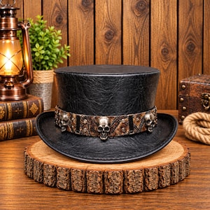 May include: A black top hat with a textured finish featuring a wide band around the base. The band has a brown snakeskin-like pattern and is decorated with three metallic silver-colored skull ornaments spaced evenly around the circumference.
